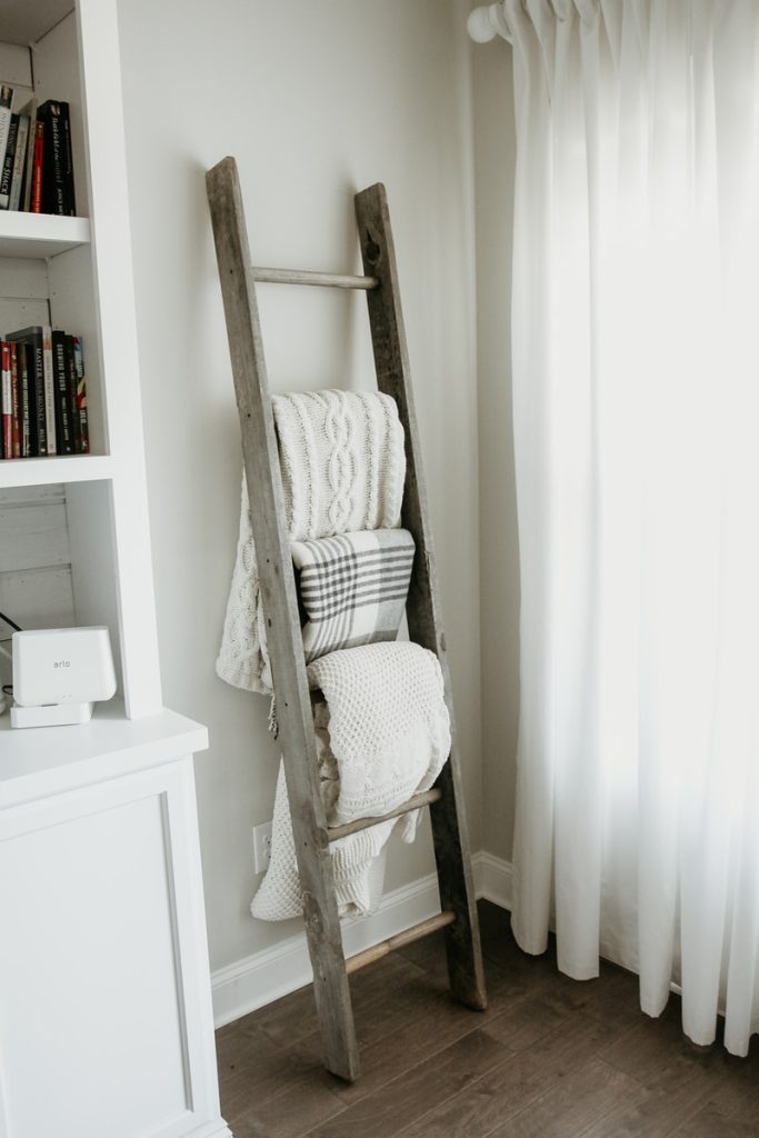 textiles hanging on gray wooden weighted blanket ladder