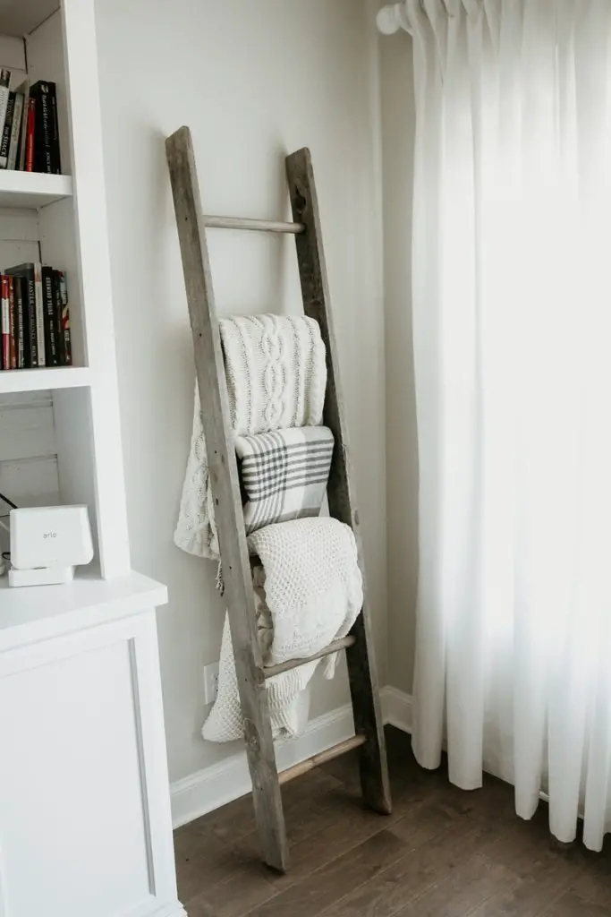 Where to Store a Weighted Blanket 2 textiles hanging on gray wooden weighted blanket ladder