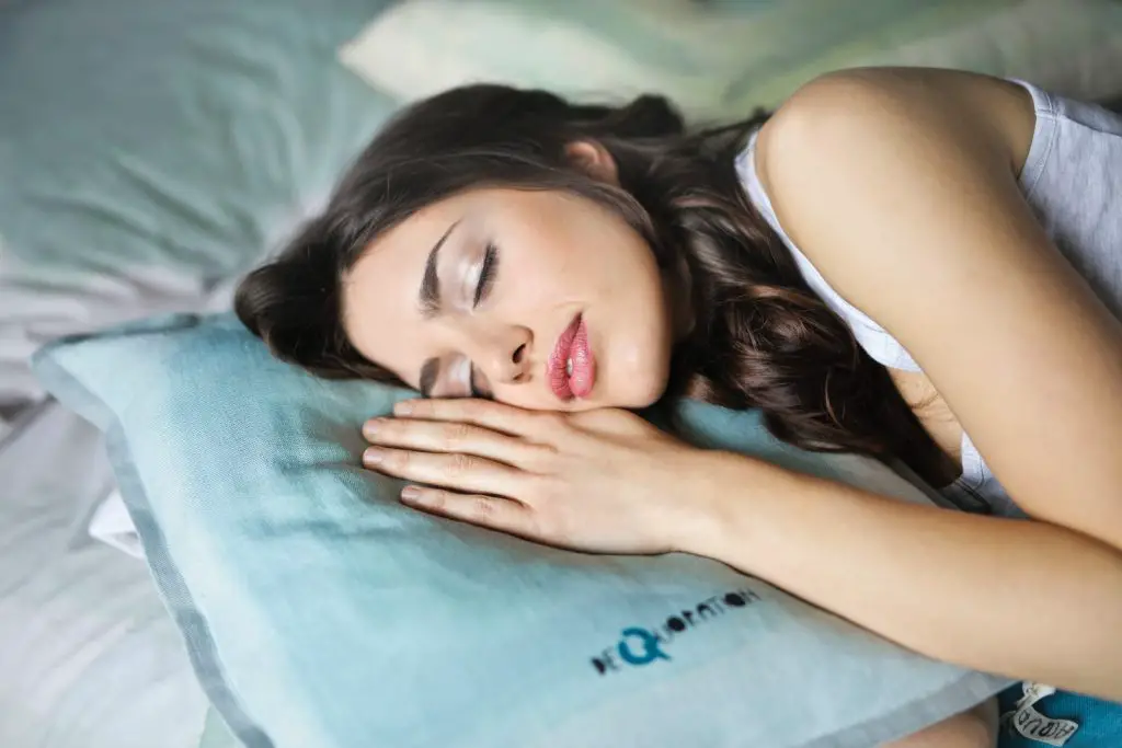 woman sleeping naked on blue throw pillow