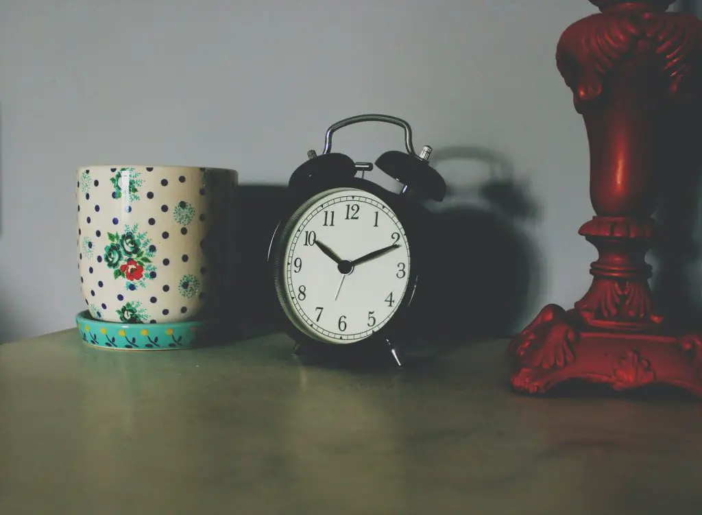black table clock beside ceramic vase 10pm sleep