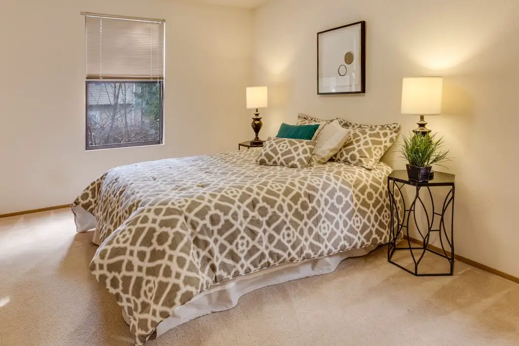 white-and-brown quatrefoil bedspread set on bed near window against the wall