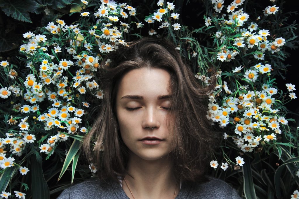 woman closing her eyes on white flower becoming heavy sleeper