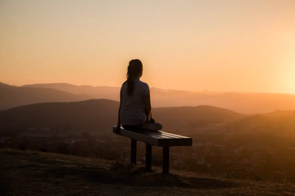 woman sitting on bench over viewing mountain morning get up early nun