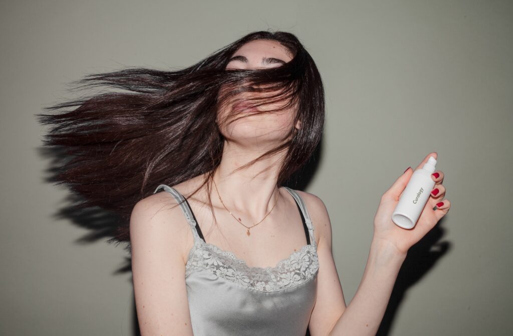 woman holding spray bottle wet hair