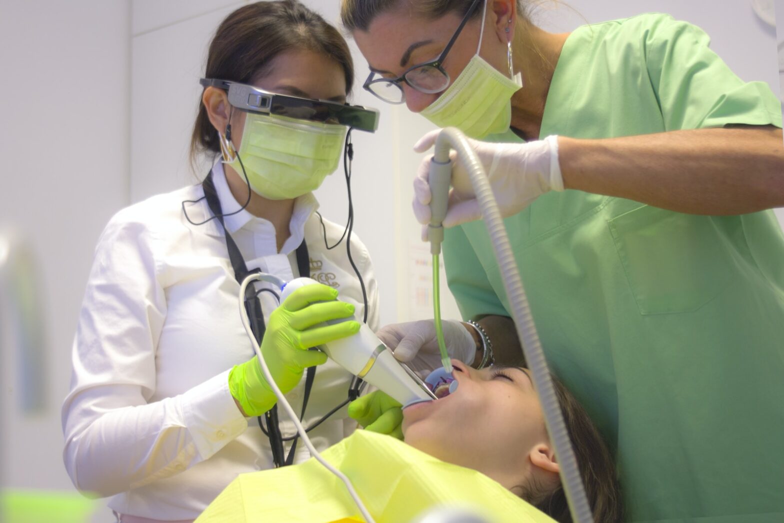man in white scrub suit holding green hose wisdom teeth extraction gauze