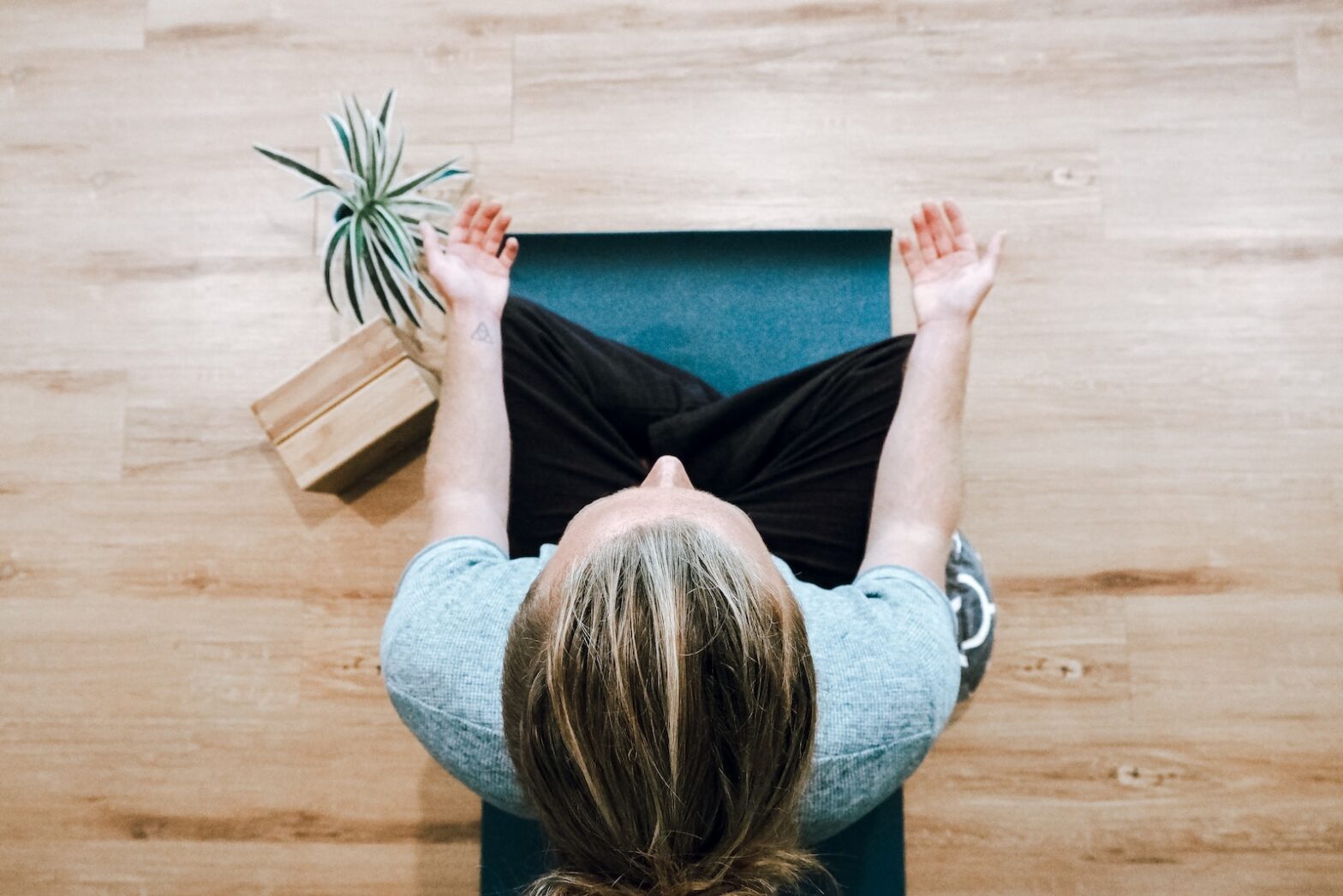 Can Yoga Nidra Replace Sleep? woman in black shirt and gray pants sitting on brown wooden bench