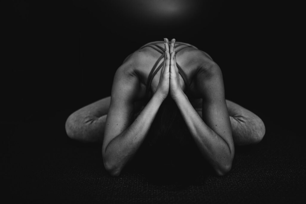 grayscale photo of naked man meditates yoga