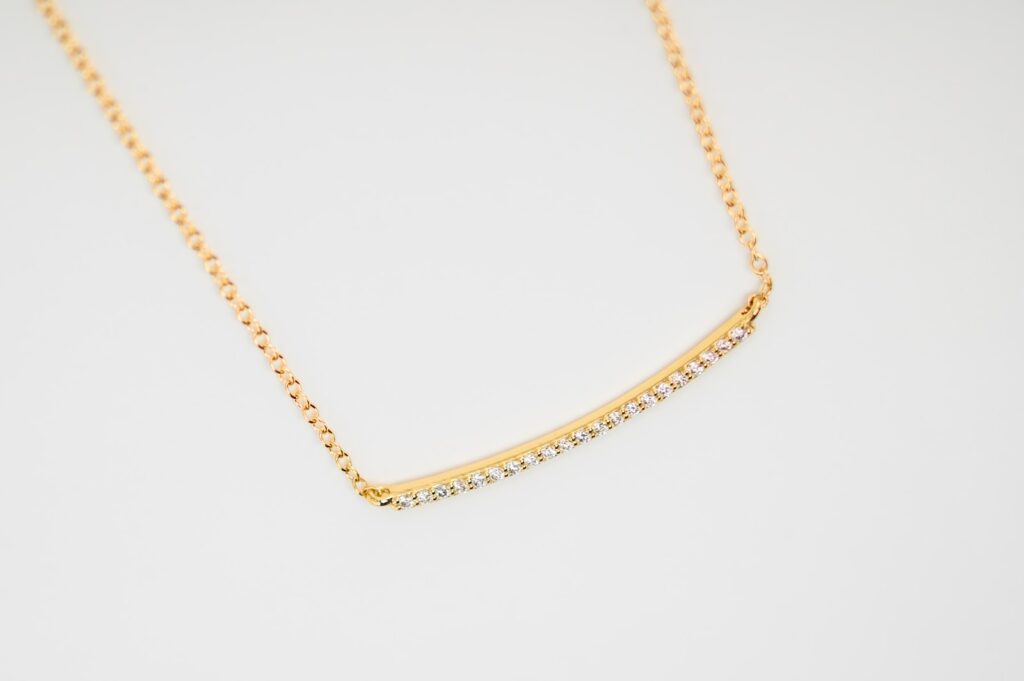 a gold necklace with a curved bar of diamonds. can you sleep with a gold chain on
