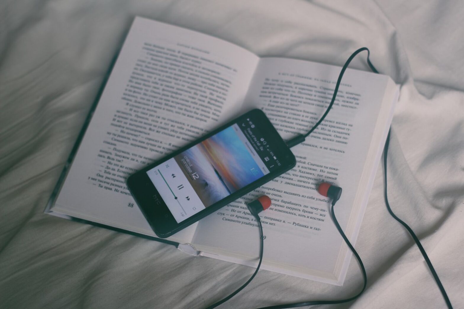 black smartphone on white book page.what happens if you sleep while listening to music
